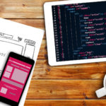 Website Wireframe Sketch And Programming Code On Digital Tablet